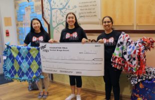 three women holding check at family house