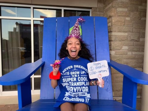 Nicole smiling on blue chair celebrating anniversary