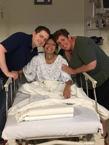 Nicole in hospital smiling with two other people