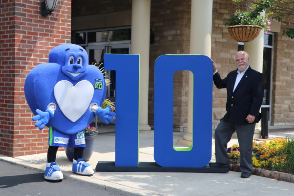 Howard with big 10 letters and heart mascot outside of family house