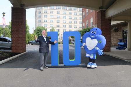 Howard with 10th anniversary numbers and donor mascot outside of FH