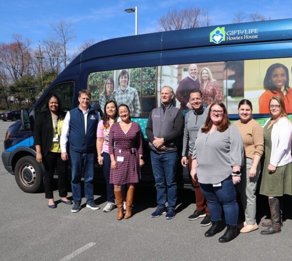 MTF Staff and Rick Hasz, CEO of Gift of Life standing in front of the Gift of Life Howie's House Shuttle.