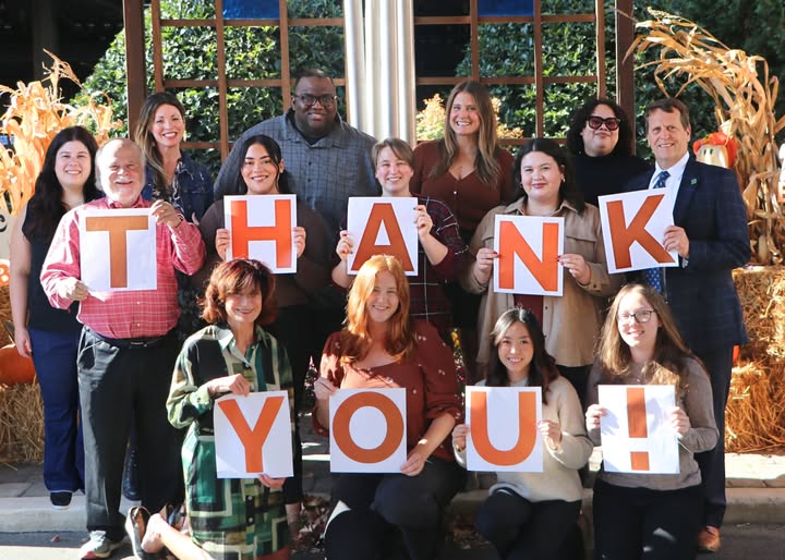 Howie's House staff gathered together outside holding letters spelling out THANK YOU!