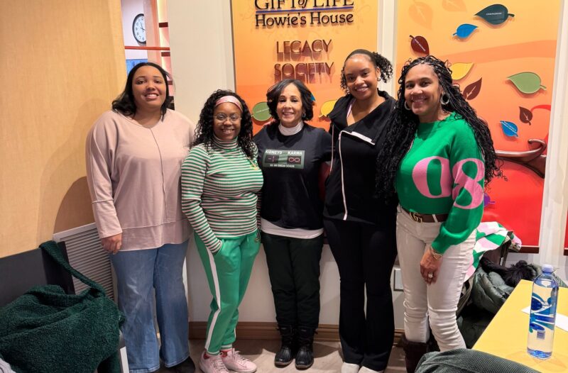 Alpha Kappa Alpha Sorority members standing in the Howie's House Entrance for a photo