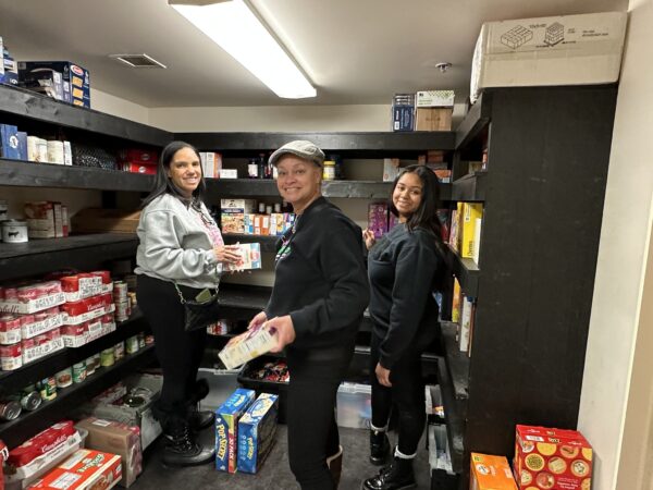 group of three organizing food items in the pantry