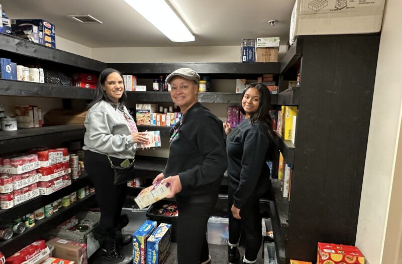 group of three organizing food items in the pantry