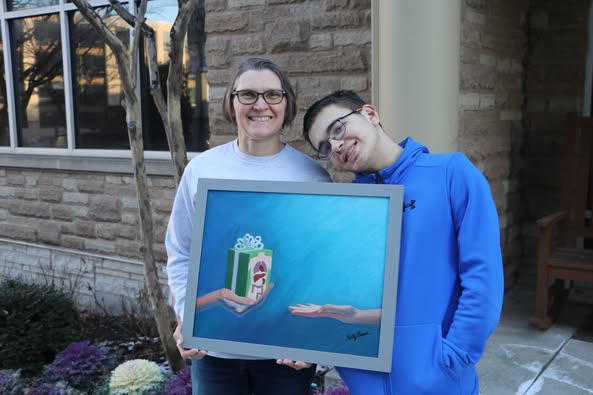 mattman and his mother now, holding a painting his mother made for last year's art contest