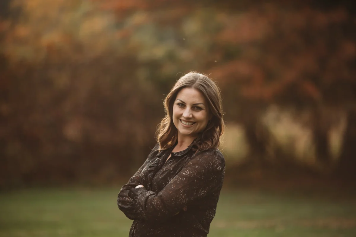 Pictured is Katherine Hamilton, Development Director standing in a wooded area smiling