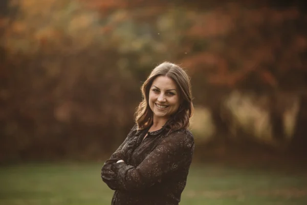 Pictured is Katherine Hamilton, Development Director standing in a wooded area smiling