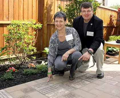 two people pointing at howie's house pavers